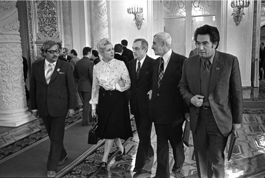 Народный артист СССР Кирилл Лавров (в середине) вместе с делегатами Третьего съезда Союза кинематографистов СССР в Георгиевском зале Московского Кремля. Среди них актриса Вия Артмане, писатели Константин Симонов и Чингиз Айтматов. Правообладатель: Мультимедийный комплекс актуальных искусств в Москве, goskatalog.ru.