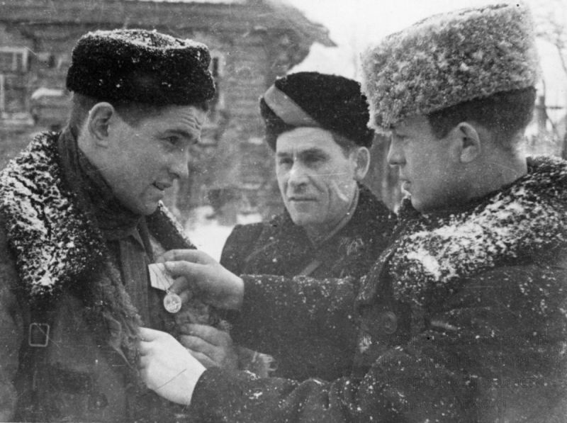 Вручение медали «За оборону Ленинграда» командиру 4-го полка 5-й Ленинградской партизанской бригады Владимиру Васильевичу Егорову (1923 — 1981). Медаль вручает командир 5-й Ленинградской партизанской бригады Константин Дионисьевич Карицкий (1913 — 2002). Фото: waralbum.ru/428837/