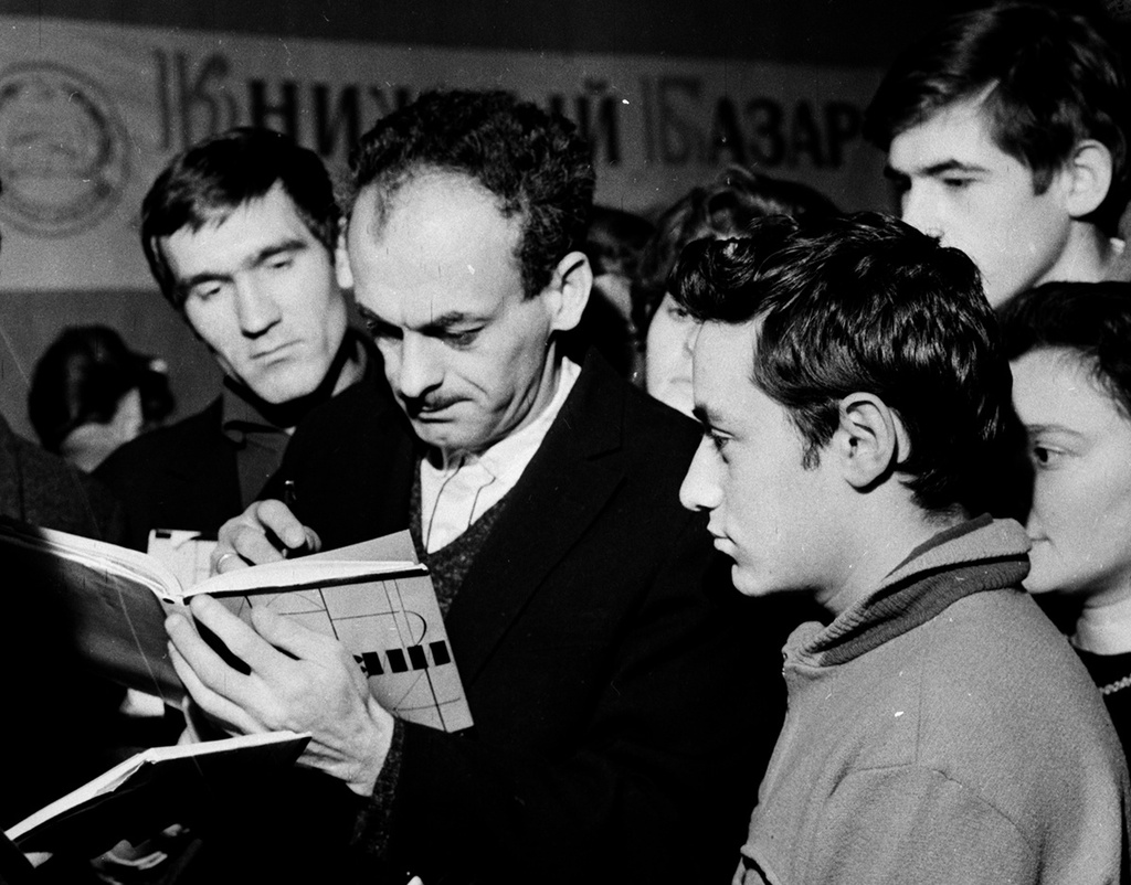 В фойе ДК ЗИЛ. Поэт Булат Окуджава и его поклонники. Автор: Валентин Хухлаев. 1964. Источник: russiainphoto.ru В фойе ДК ЗИЛ. Поэт Булат Окуджава и его поклонники. Автор: Валентин Хухлаев. 1964. Источник: russiainphoto.ru
