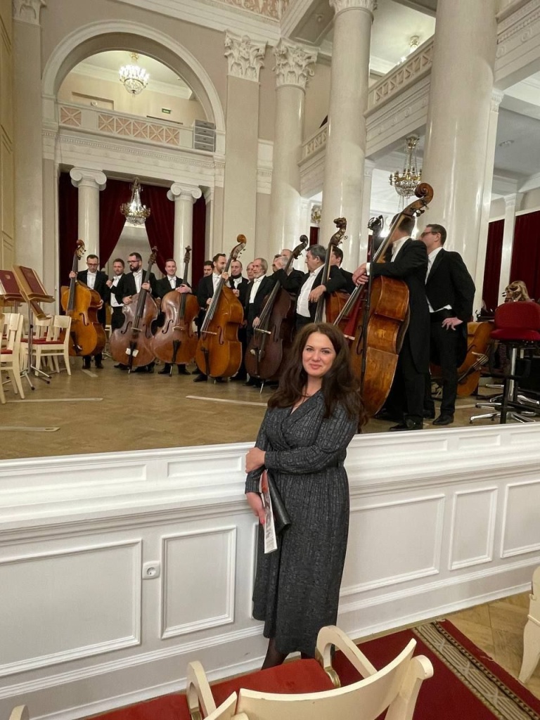 На фоне оркестра.